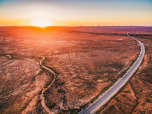 Orange Sunset Over Dry Land And Rural Highway Winding Through In South Australia