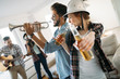 © NDABCREATIVITY - Cheerful friends having party together and playing instruments