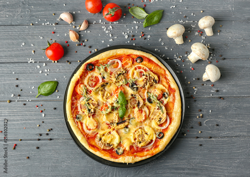 Composition with tasty pizza and ingredients on wooden background, top view