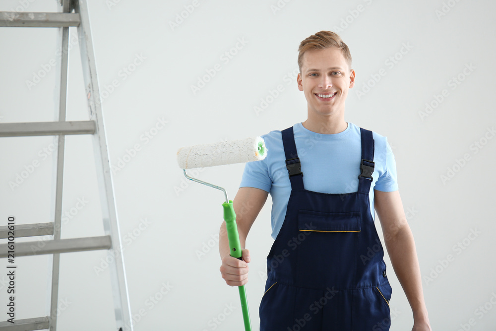 Young painter with roller indoors
