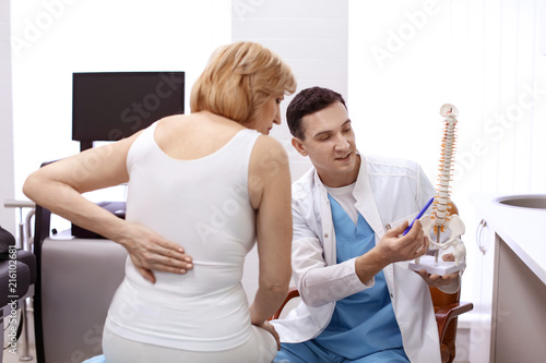 Fotomural Orthopedist showing spine model to patient in hospital