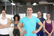 © Pixel-Shot - Sporty man with group of athletes in gym