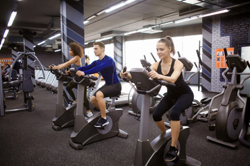 Sticker - Young people doing exercises on elliptical trainer in gym