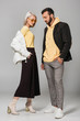 © LIGHTFIELD STUDIOS - stylish young man and woman in autumn outfits posing on grey background