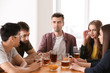 © Pixel-Shot - Group of friends drinking beer in bar