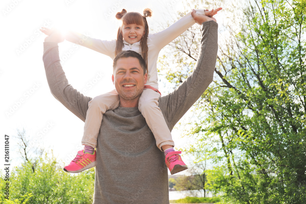 Cute little girl with father in park