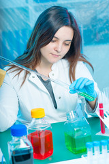 Sticker - Young attractive female scientist  load liquid sample substance probe in the scientific chemical research laboratory