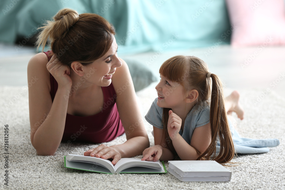 Mother and her daughter reading book together at home