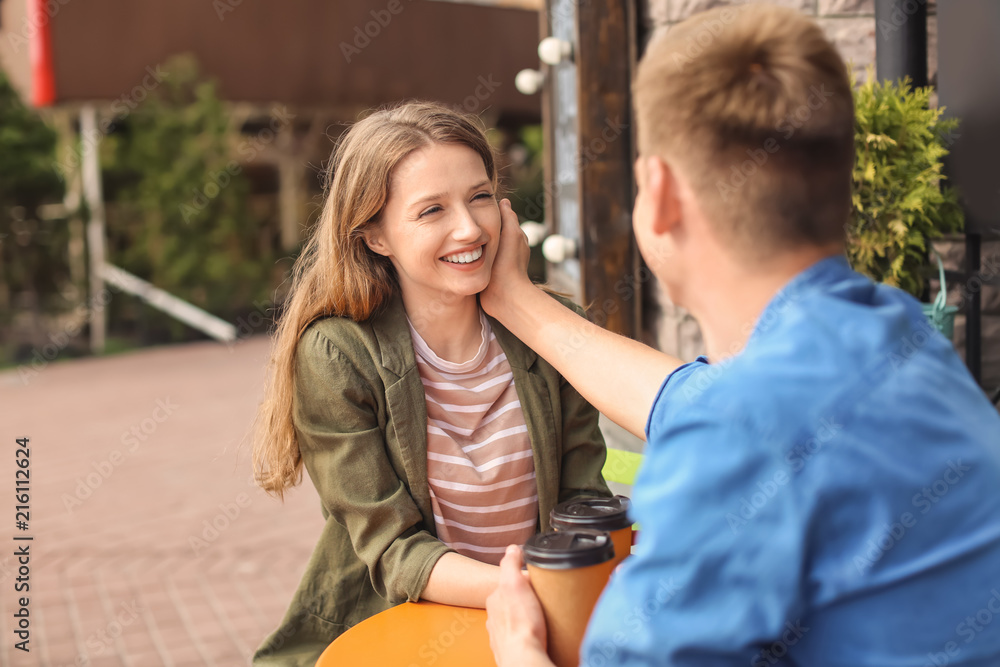 Happy young couple in cafe outdoors