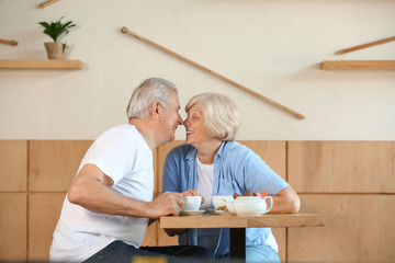 Wall Mural - Happy senior couple sitting together in cafe