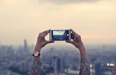 Wall Mural - Woman taking a photo of the sunset