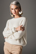 © LIGHTFIELD STUDIOS - attractive girl posing in white knitted sweater and round earrings, isolated on grey