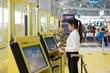 © Prasit Rodphan - Young Asian businesswoman using self check-in kiosks in airport. Technology in airport.