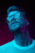 © monchak - Neon light studio portrait of man model with mustaches and beard in sunglasses and white t-shirt