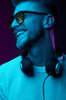© monchak - Neon portrait of smiling man with headphones on neck,in sunglasses and white t-shirt.