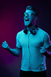 © monchak - Neon portrait of screaming man with headphones on neck, in yellow glasses, white t-shirt