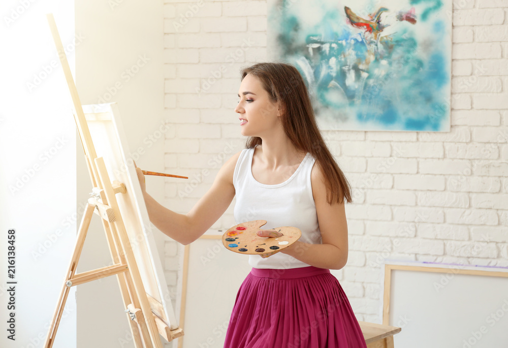 Female artist painting picture in workshop