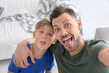 Wall Mural - Little boy with his dad taking selfie at home