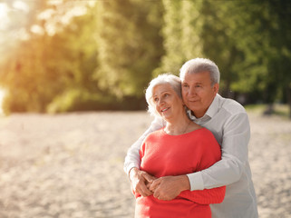 Wall Mural - Happy mature couple on beach near park