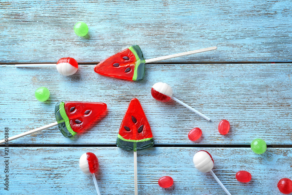 Colorful candies with lollipops on light wooden background