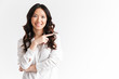 © Drobot Dean - Joyful asian woman with long dark hair looking at camera with beautiful smile and pointing finger aside at copyspace text or product, isolated over white background in studio