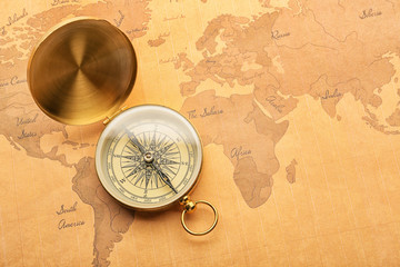 Canvas Print - Golden compass on vintage world map. Travel planning concept