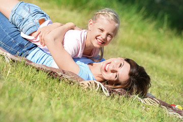 Happy mother and daughter playing in park