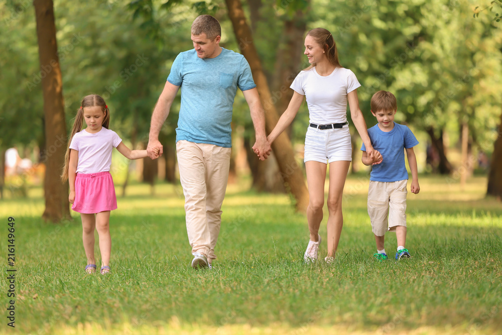 Happy family walking together in green park Stock Photo | Adobe Stock