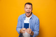 © Drobot Dean - Happy man isolated over yellow background holding passport.