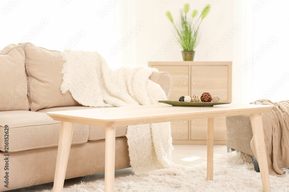 Stylish interior of living room with comfortable sofa and table