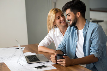 Wall Mural - Photo of cheerful loving young couple using laptop