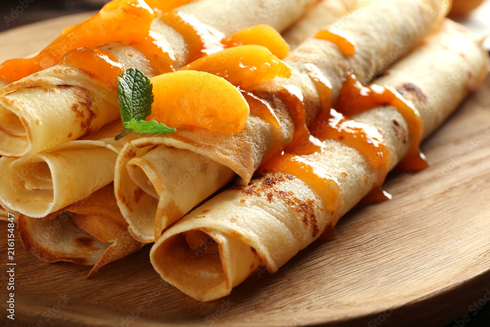 Plate with tasty pancakes and apricot jam, closeup