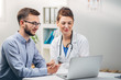 © Suteren Studio - Doctor and Intern Looking at Test Results on Laptop