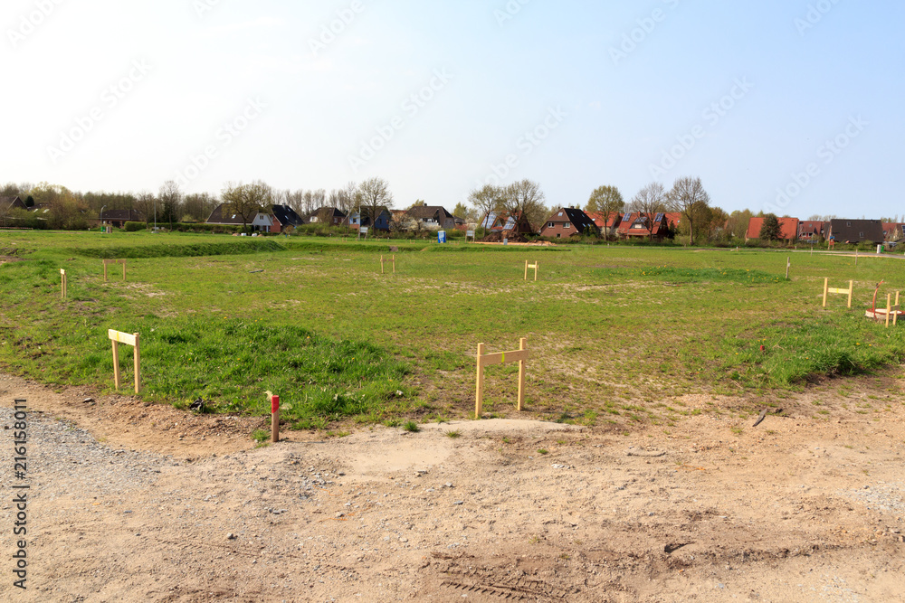 Building lot site with grass after stakeout measurement survey ready for construction, Germany - obrazy, fototapety, plakaty 