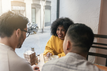 Group of happy friends chatting in the coffee shop.