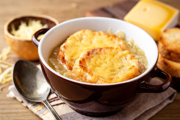 Wall Mural - French onion soup with croutons and cheese on rustic wooden table