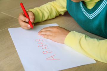 Wall Mural - little boy learning to write letters doing homework