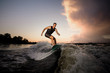© fesenko - Active strong young man riding down the river waves in beautiful summer evening