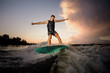 © fesenko - Young athletic man wakesurfing down the river waves