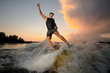 © fesenko - Athletic man wakesurfing down the river waves