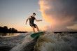 © fesenko - Young man wakesurfing down the river waves