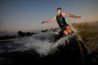 © fesenko - Muscular young man wakesurfing down the river waves
