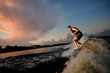 © fesenko - Athletic man riding on wakesurf down the river