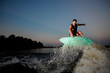 © fesenko - Attractive man riding on wakesurf down the river during sunset
