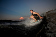 © fesenko - Young and active man riding on wakesurf down the river during summer sunset