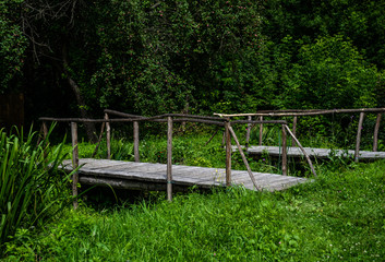 Poster - Old wooden bridge and green meadow. Scenic countryside