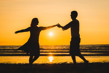 Wall Mural - Beautiful silhouettes of dancers at sunset