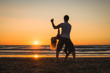 Wall Mural - Beautiful silhouettes of dancers at sunset