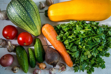 Wall Mural - Fresh vegetables and parsley on a white wooden table.