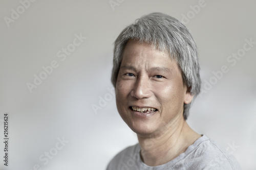 Chinese Man With Gray Hair Looking Towards Camera And